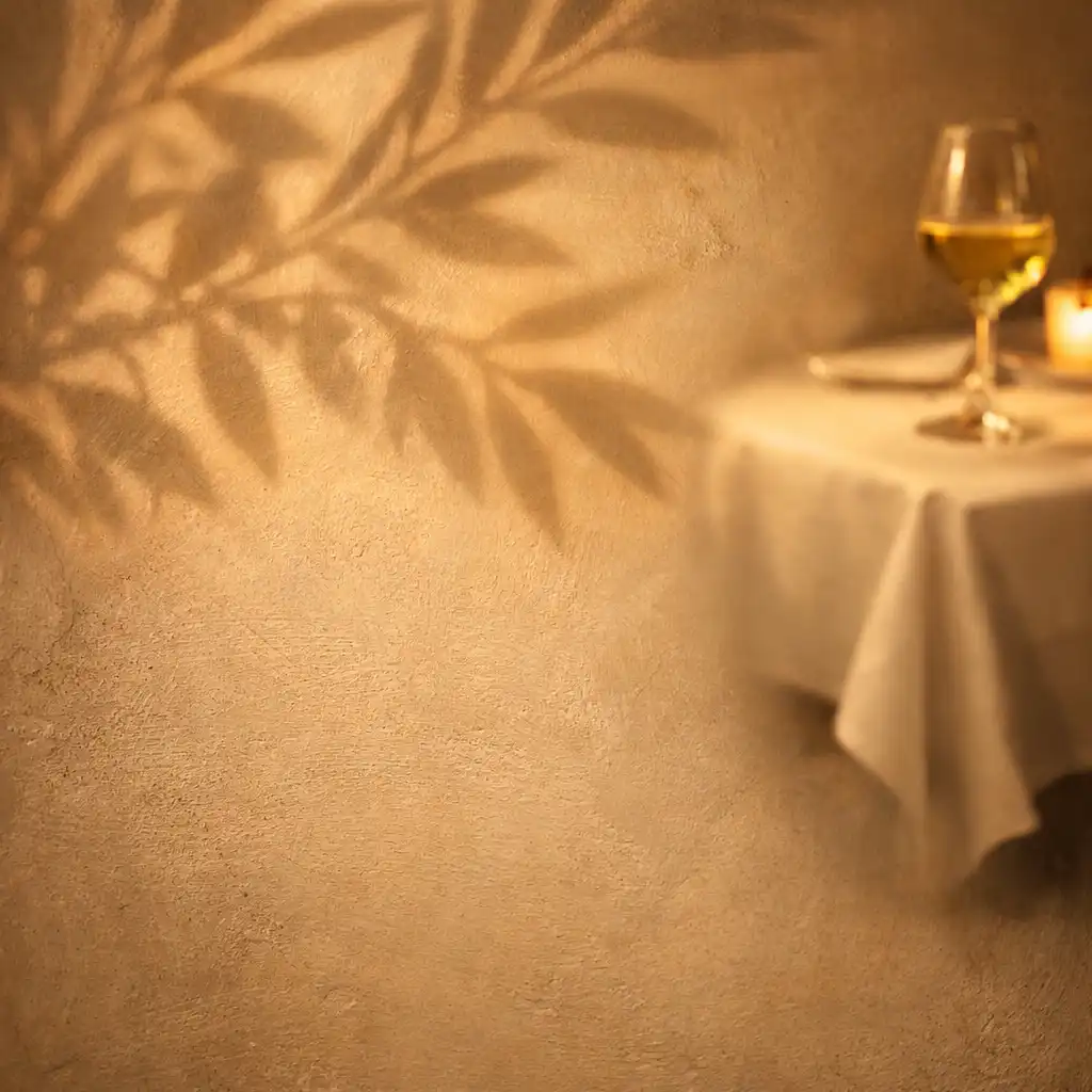 Cienie liści oliwnych na ścianie restauracji rzucane przez światło świec
